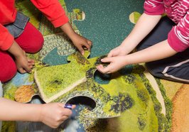 Kinderhände an einem großen Puzzle. Foto: Stadt Oldenburg