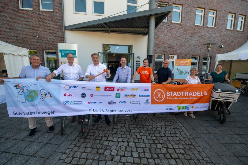 Christian Bunk, Vertriebsdirektor, Öffentliche Versicherungen Oldenburg, Olaf Meenen, Abteilung Vorstandsstab und Geschäftsführer der LzO Stiftungen, Landessparkasse zu Oldenburg, Jürgen Krogmann, Oberbürgermeister, Stadt Oldenburg, Holger Sandker, Director Head of Sustainability, Oldenburgische Landesbank AG, Christian Lüdke, Vorstandsvorsitzender, ADFC Oldenburg e.V., Nils Linge, Pressesprecher, ADAC Weser-Ems e.V., Kerstin Goroncy, Koordinatorin STADTRADELN, Stadt Oldenburg und Gabriele Duwe, Produktentwicklung, Oldenburg Tourismus und Marketing GmbH stehen beim Startschuss zum STADTRADELN in Oldenburg hinter einem STADTRADELN-Banner. Foto: Sascha Stüber