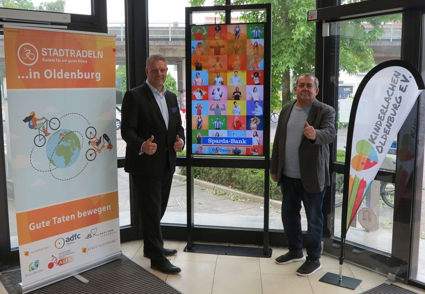 Hermann Kruse, Filialleiter der Sparda-Bank West eG, und Horst Häuser, Vorstandsvorsitzender von Kinderlachen Oldenburg, freuen sich über das Erreichen des Etappenziels. Foto: Stadt Oldenburg