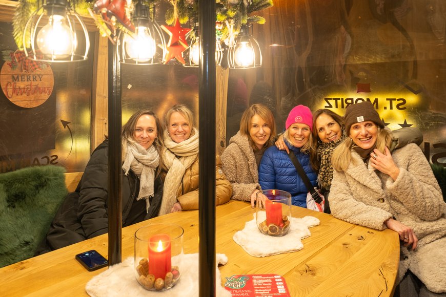 Eine Besuchergruppe in der Gondel bei der Feuerzangenbowle „Home Sweet Elf“ auf dem Lamberti-Markt 2025. Foto: Sascha Stüber