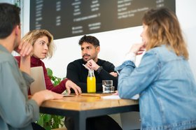 Menschen sitzen am Tisch und sprechen miteinander. Foto: Kampus Productuion/Pexels