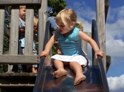 Drei Kinder auf einem Klettergerüst mit Rutsche. Foto: knipseline/pixelio.de