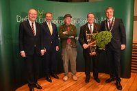 Boris Pistorius (2. von r.) ist neuer Grünkohlkönig. Sein Vorgänger, Christian Lindner (2. von l.), Stephan Weil (l.) und Jürgen Krogmann (r.) statteten ihn mit Königskette und Kohlpalme aus. Dietmar Wischmeyer (Mitte) hielt die Rede. Foto: v. Reeken