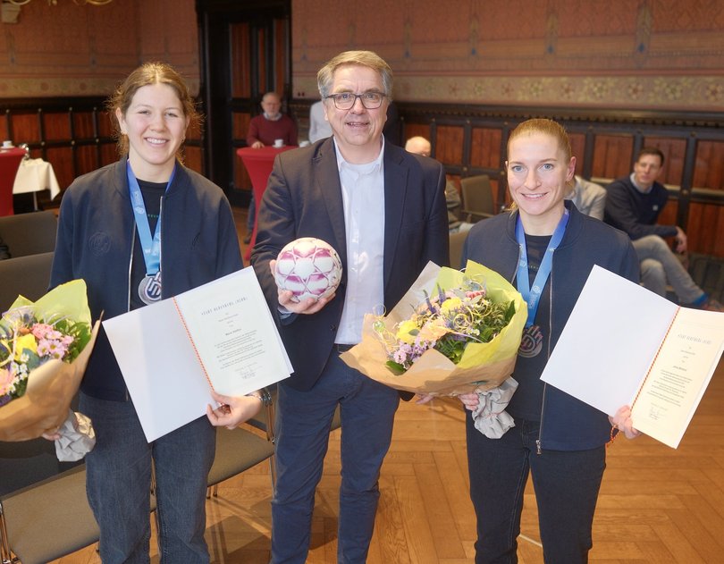 Mit Handball, Blumen und Urkunden: Oberbürgermeister Jürgen Krogmann gratulierte den Silbermedaillengewinnerinnen Marie Steffen (links) und Jenny Behrend zu ihrem herausragenden Erfolg. Foto: Sascha Stüber 