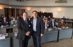 Der stellvertretende Ratsvorsitzende Berndt Benjamins aus Groningen und Oberbürgermeister Jürgen Krogmann stehen nebeneinander. Hinter ihnen sitzen die weiteren Teilnehmenden. Foto: Stadt Oldenburg