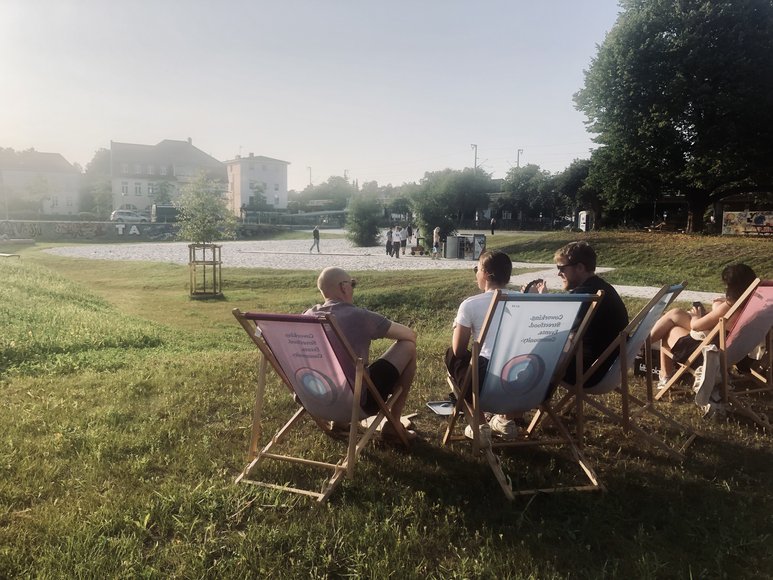 Menschen sitzen Abends in Liegestühlen auf der Rasenfläche. Foto: Stadt Oldenburg