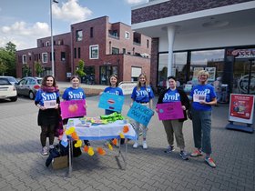 Sechs Frauen aus dem StoP Frauentisch auf einem Einkaufsparkplatz mit Infomaterialien und Plakate. Foto: Stadt Oldenburg