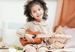 Mädchen spielt Ukulele. Foto: Pexels