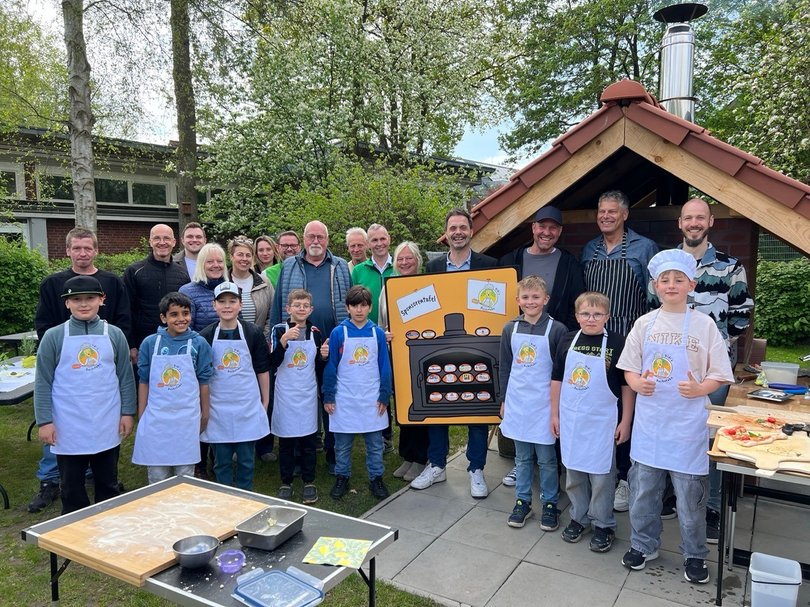 Kleine Bäckerinnen und Bäcker backen Großes: Stolz präsentieren Kinder und Erwachsene den Holzbackofen der Grundschule Dietrichsfeld. Foto: Grundschule Dietrichsfeld