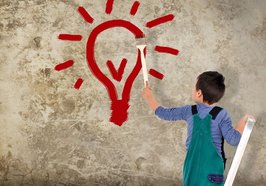 Junge malt eine Glühbirne an die Wand. Foto: S. Kobold/Fotolia.com