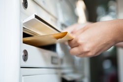 Hand, die Post in einen Briefkasten steckt. Foto: apops/Fotolia.com