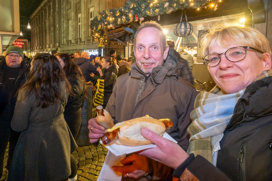 Besuchende mit Bratwurst auf dem Lamberti-Markt 2025. Foto: Sascha Stüber