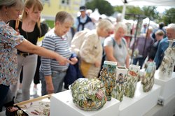Menschen schauen sich Vasen aus Keramik an. Foto: Werkschule e.V., Markus Hibbeler