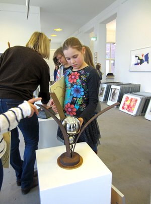 Kinder betrachten Kunstwerke in der Artothek