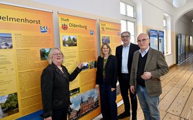 Museumskuratorin Etta Bengen (1. von links), Dr. Franziska Meifort (Landschaftsdirektorin, Oldenburgische Landschaft, 2. von links), Oberbürgermeister Jürgen Krogmann (2. von rechts) und Dr. Jörgen Welp (stellvertretender Geschäftsführer, Oldenburgische Landschaft, 1. von rechts) in der Jubiläumsausstellung, hier mit dem Roll-Up der Stadt Oldenburg. Foto: Sascha Stüber