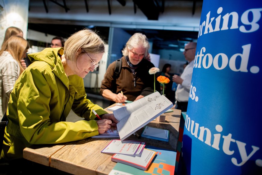 Eine Bürgerin liest in der Broschüre „ISEK Zukunft 2050“ und schreibt ihre Anmerkung auf einem Zettel. Foto: Hauke-Christian Dittrich